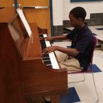 This picture shows Justin Robinson playing piano in one of our music rooms.